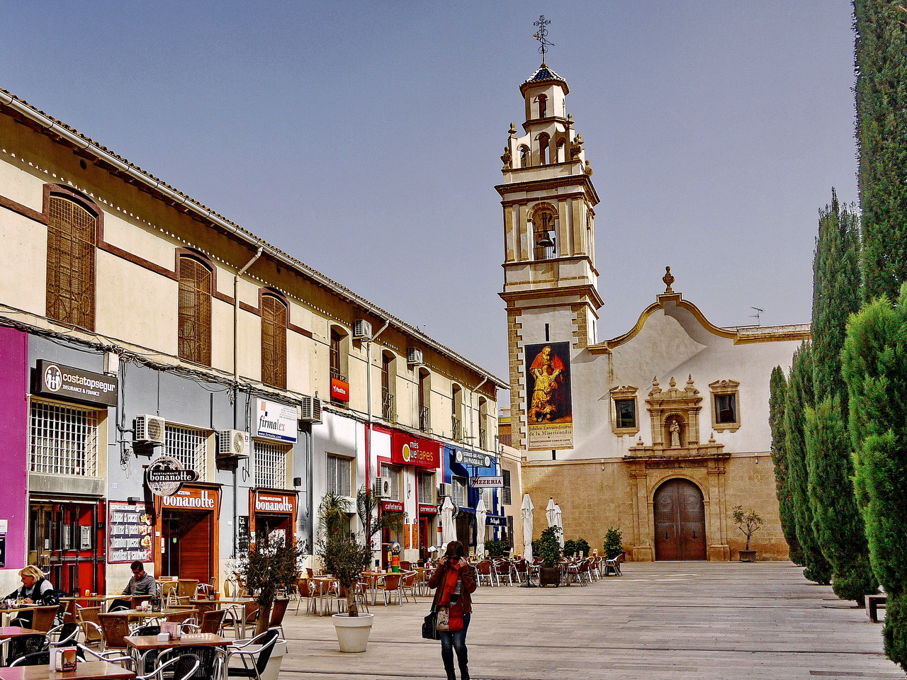 Platz in der Altstadt mit Kirche und Bars, mit Stühlen und Tischen im Freien